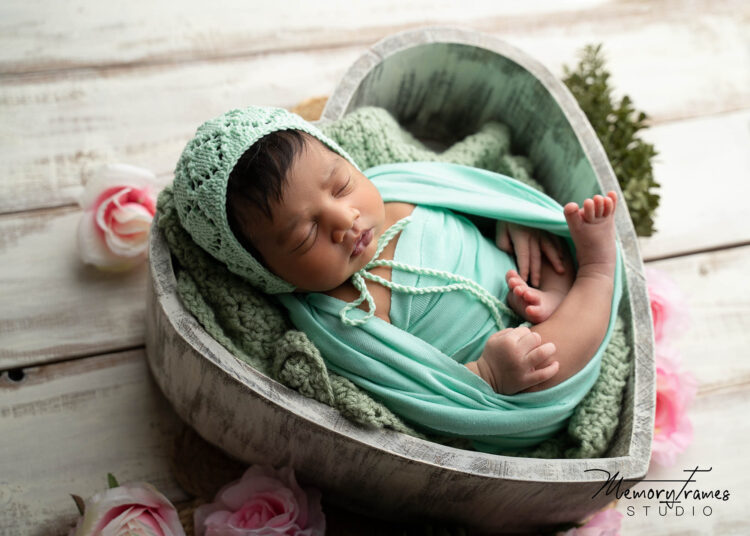 baby sleeping in heart bowl for in home newborn photoshoot, how to take newborn photos at home