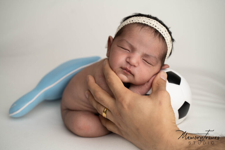 kitchener newborn photographer posing baby with a ball at kitchener studio